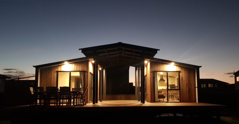 Tiny Lander transportable tiny house by Modular Dwellings with modern modular design and outdoor living area at dusk